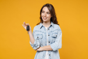 A person holding the keys to their new 2026 Acura MDX on a yellow background